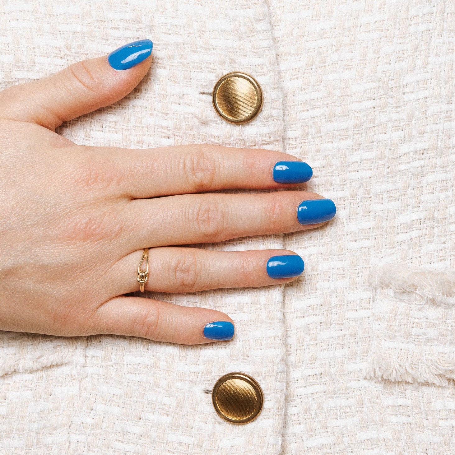 Bobby Blue Maniac Nails bright blue gel stickers on hand with gold buttons