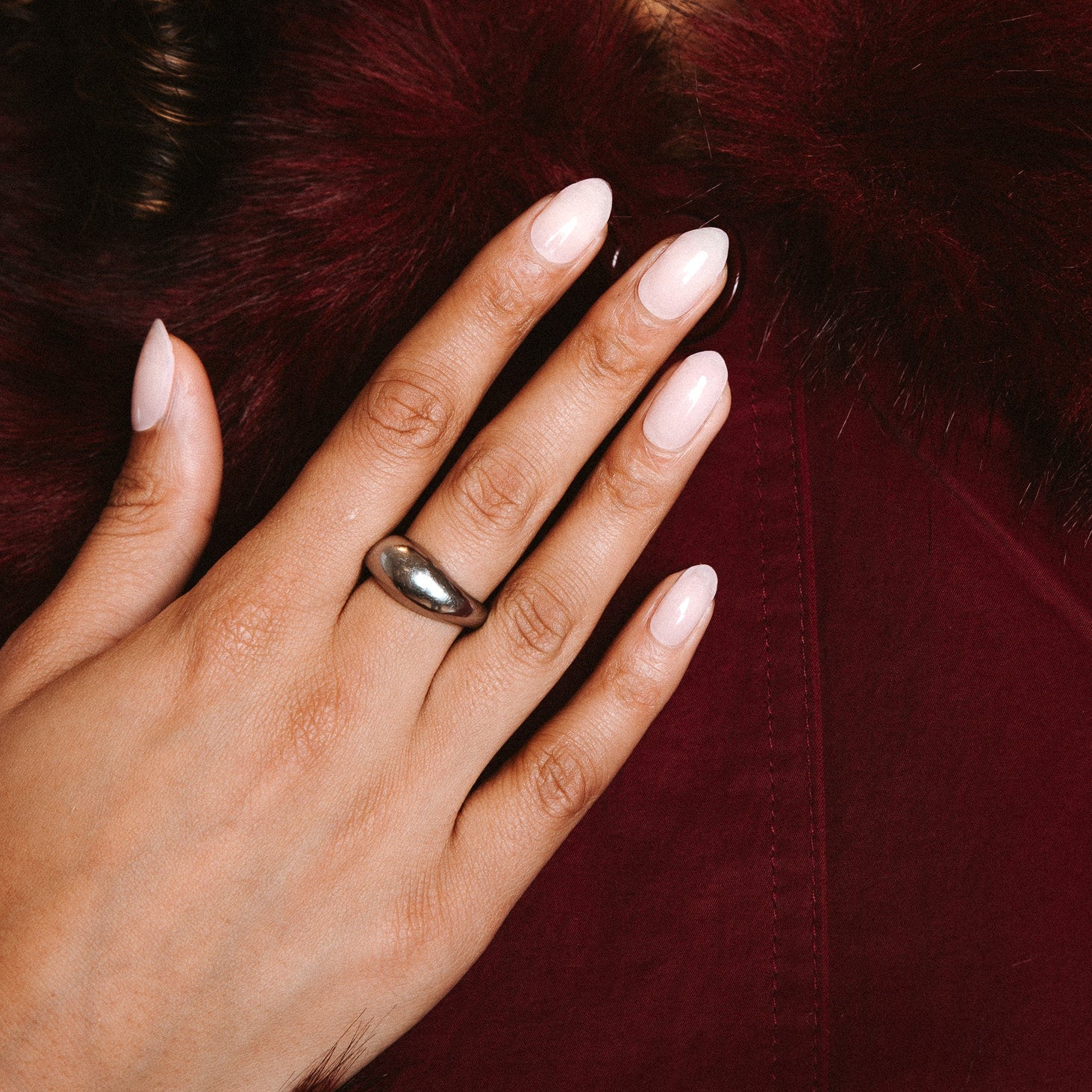 Family first Maniac nails Anna Nooshin design light pink on nail with gold ring and dark red jacket with fur