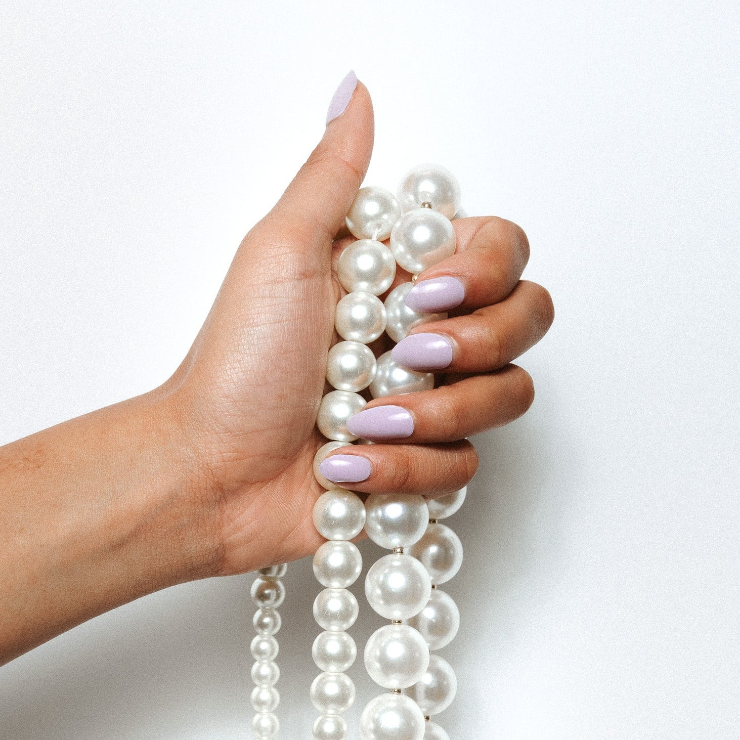 Giselle Gray Maniac Nails grey pearle nail design sticker on hand with pearl necklace