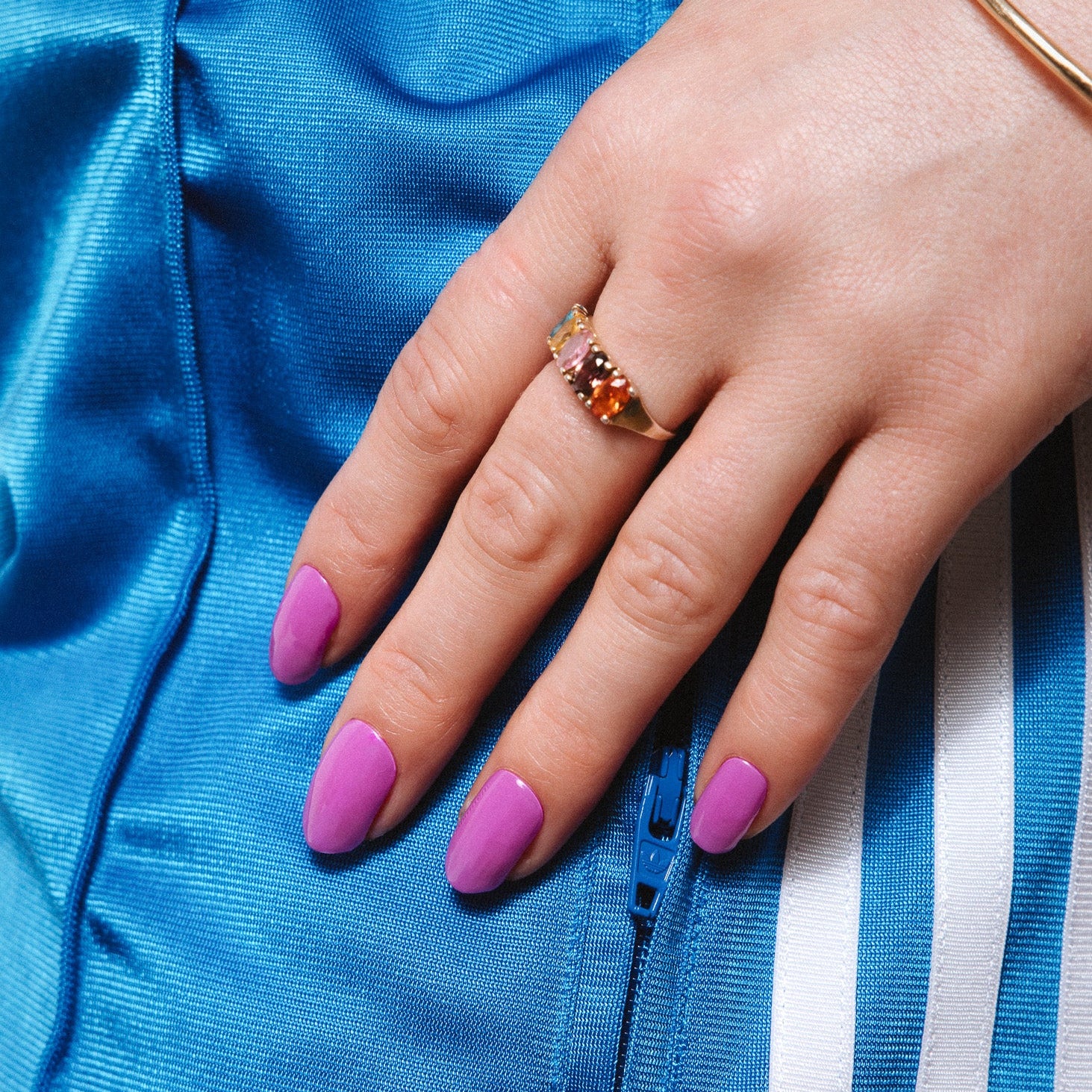 Pukka Purple Maniac Nails bright purple nail design sticker on hand with blue adidas pants