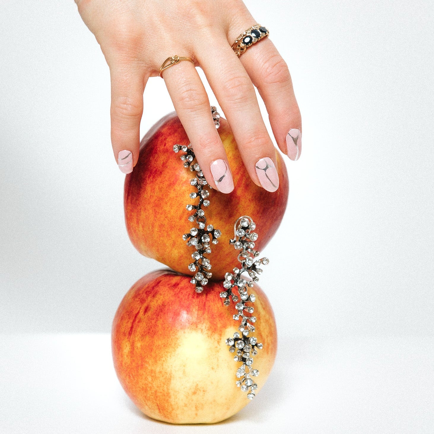 Silverline Bliss Maniac Nails light pink with silver marble lines nail art design stickers on hand with apple and silver earrings