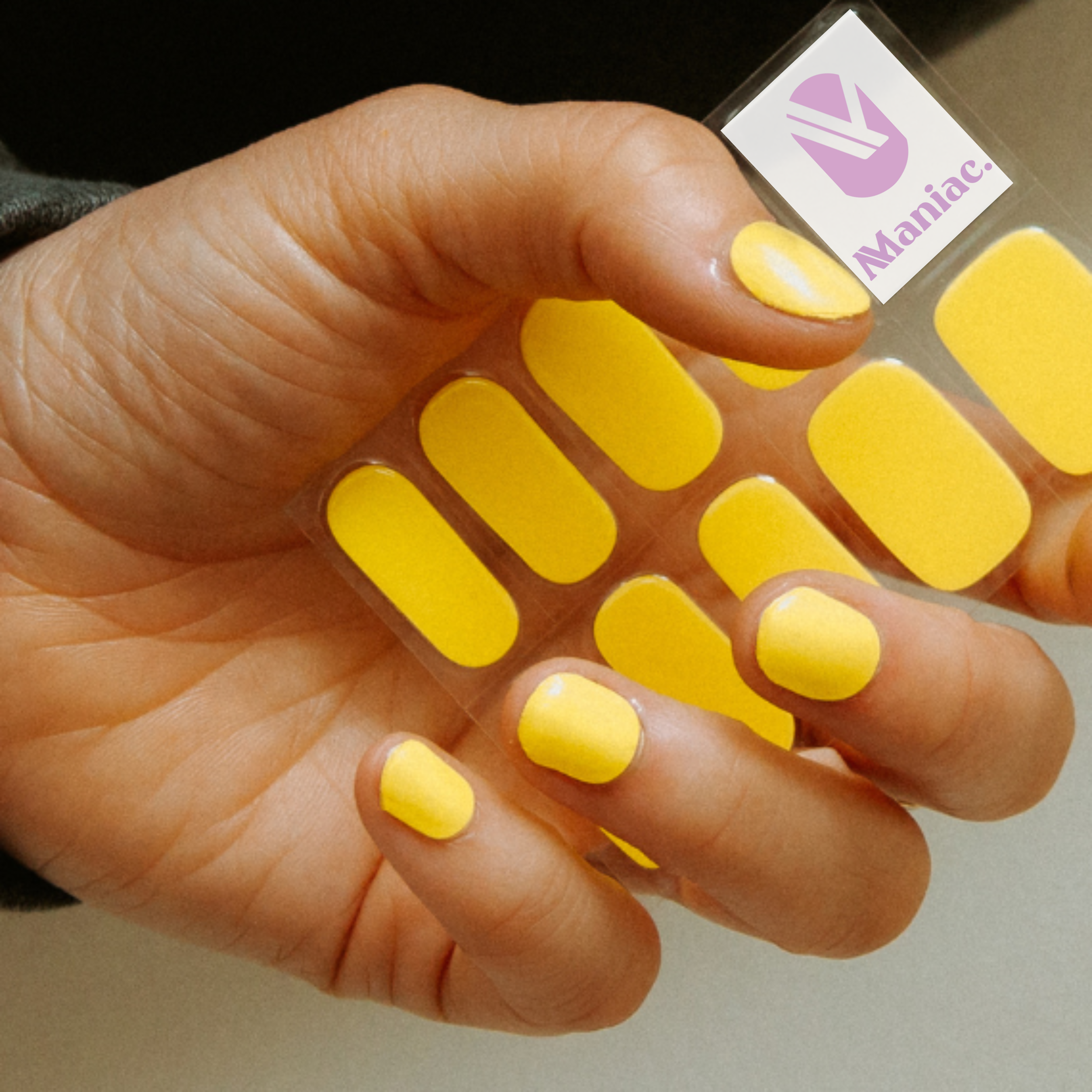 Hand met knal gele gellak sticker sheet vasthoudend