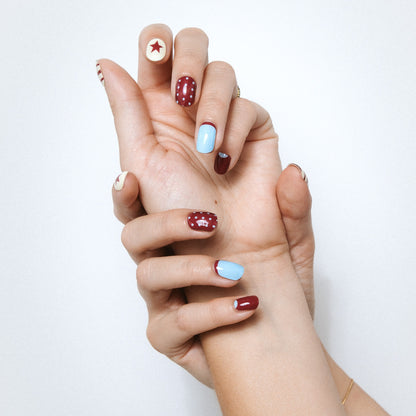 Hands with All In gel nail stickers by Maniac Nails, mix and match bordeaux and baby blue manicure