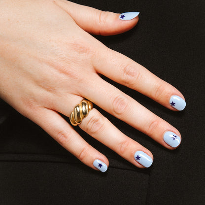 Close-up of Blue Wish gel nail stickers by Maniac Nails, soft blue manicure with navy stars