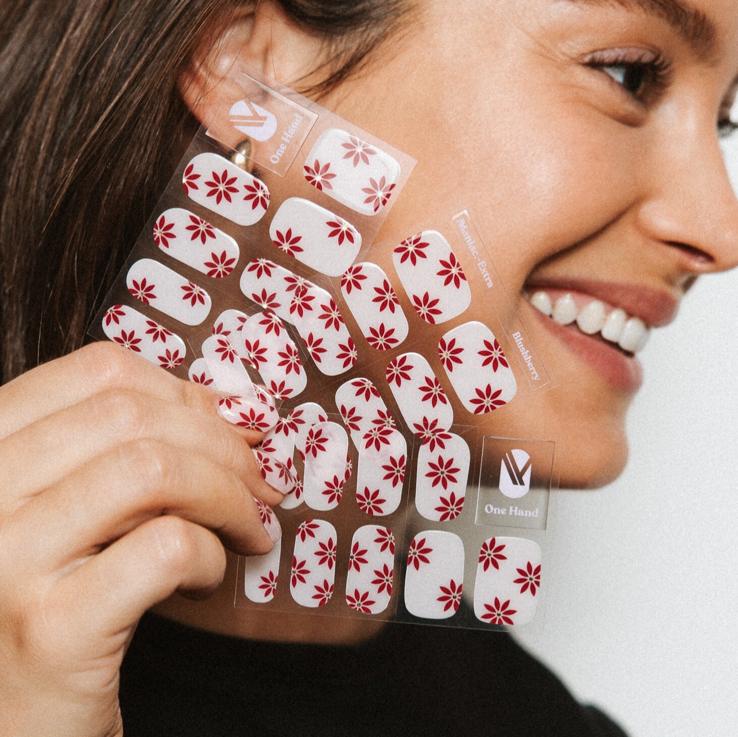 Blushberry Maniac Nails on sheet with red with gold flower on pink nail art and girl smiling 