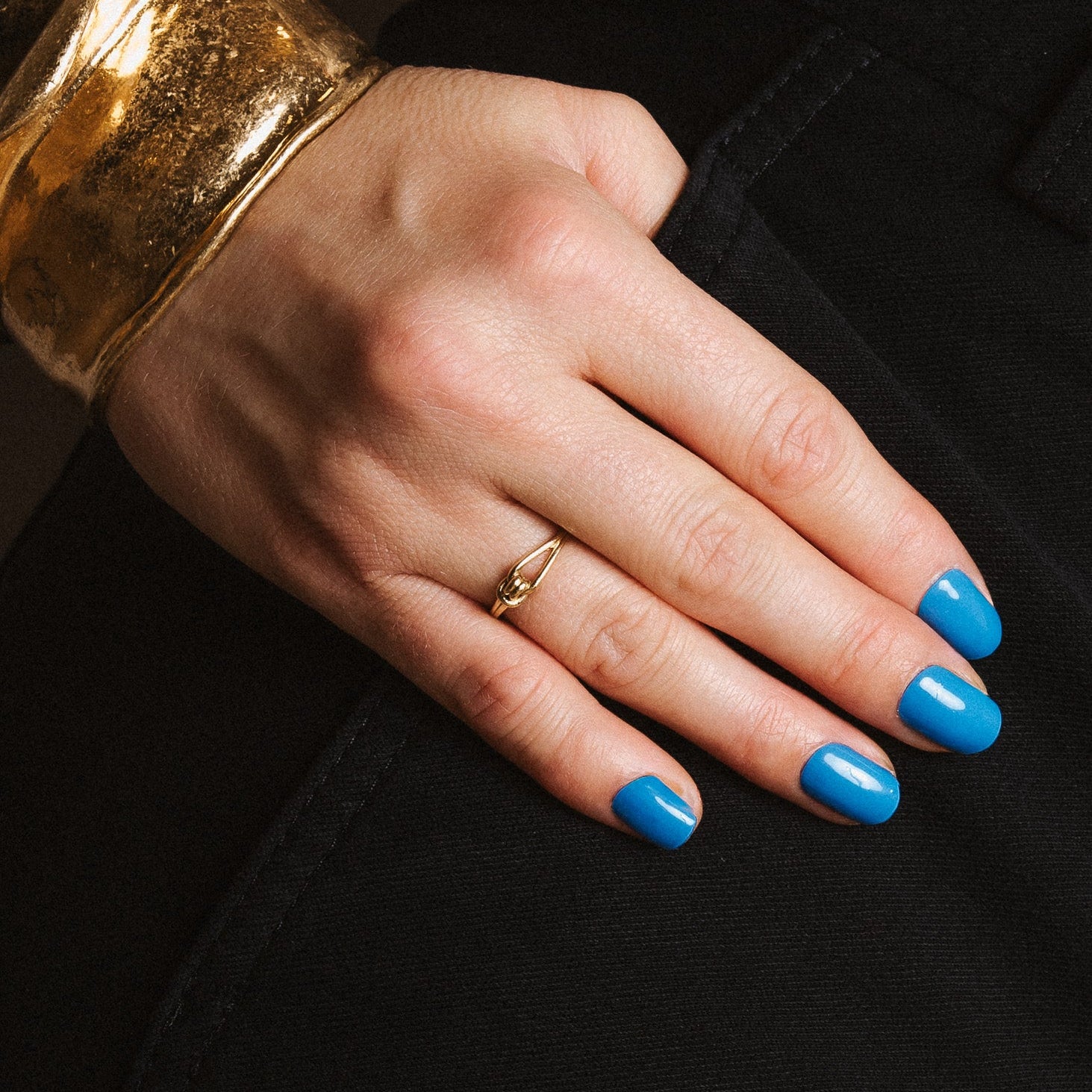 Bobby Blue Maniac nails bright blue gel stickers on hand with gold bracelet 