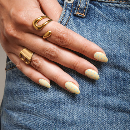 Close-up of Butter Dots gel nail stickers by Maniac Nails on denim, soft yellow nails with dots