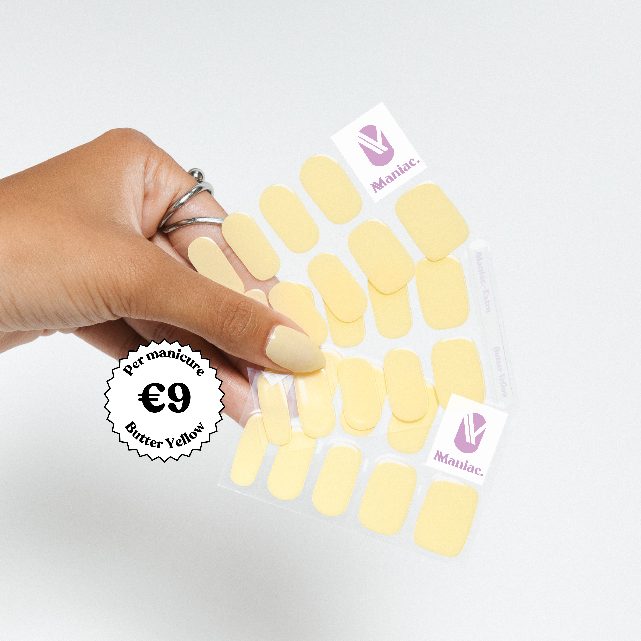 Hand holding a pack of yellow nail stickers with 'Maniac' branding on a white background.