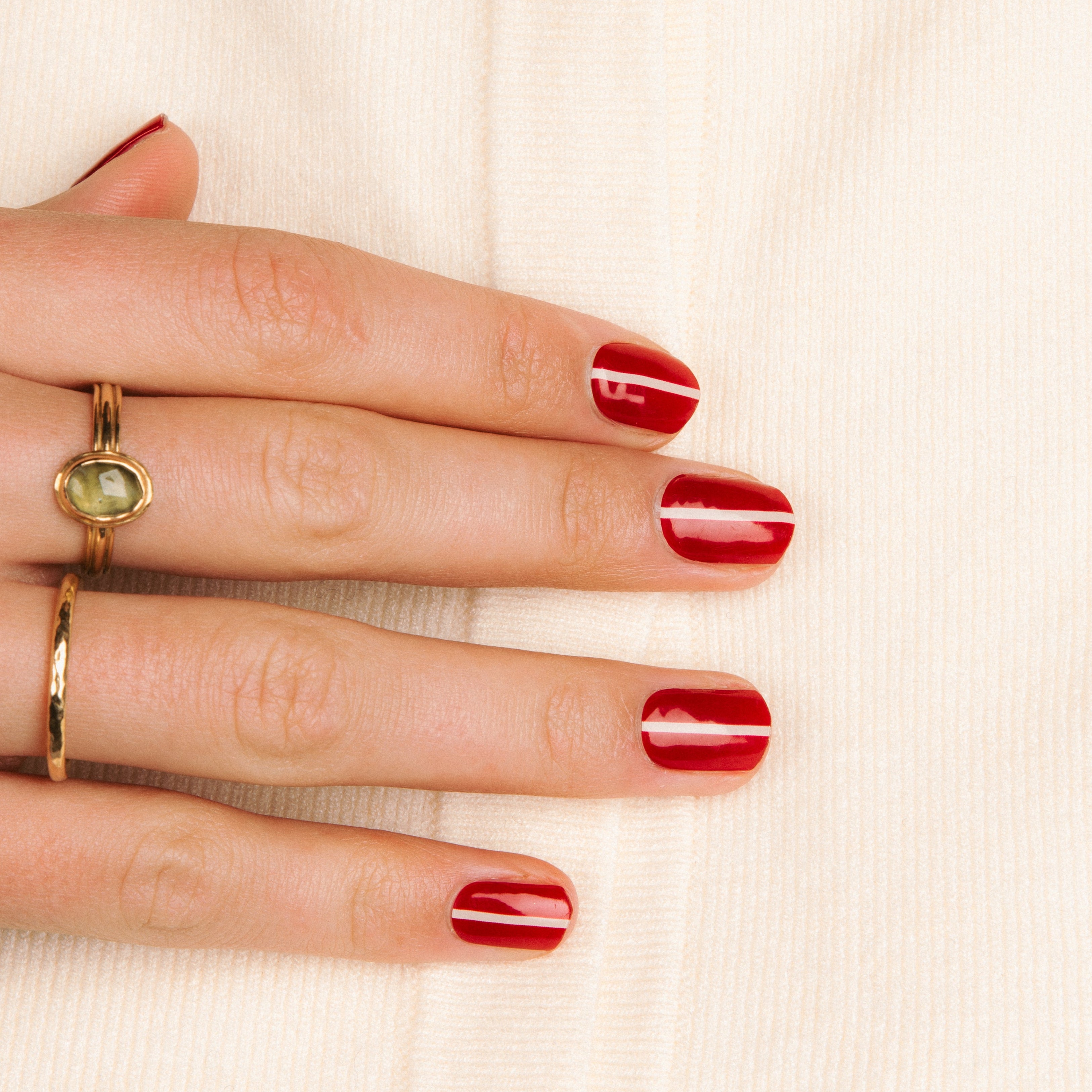Datenightchic hand met rode nagels en een wit streepje