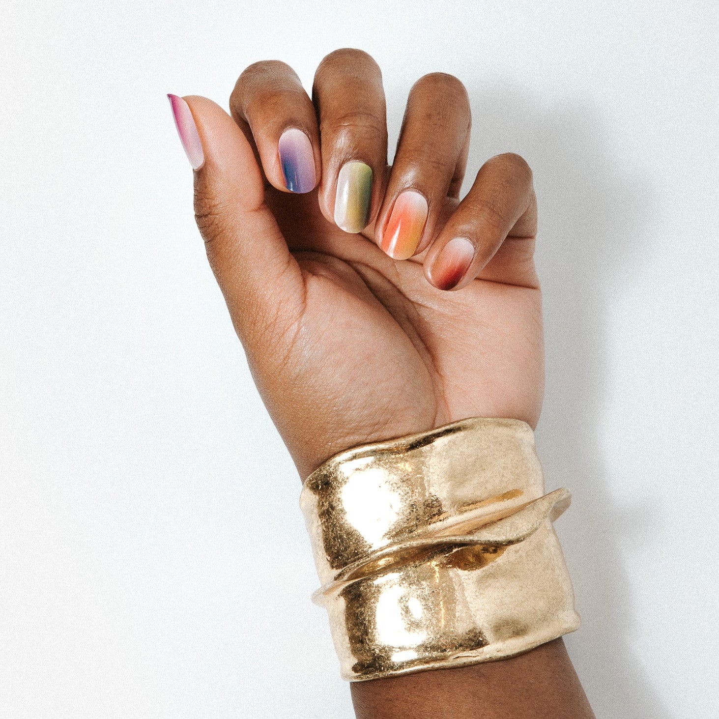 Every Mood Maniac Nails multi colors comined and faded on hand with gold bracelet 