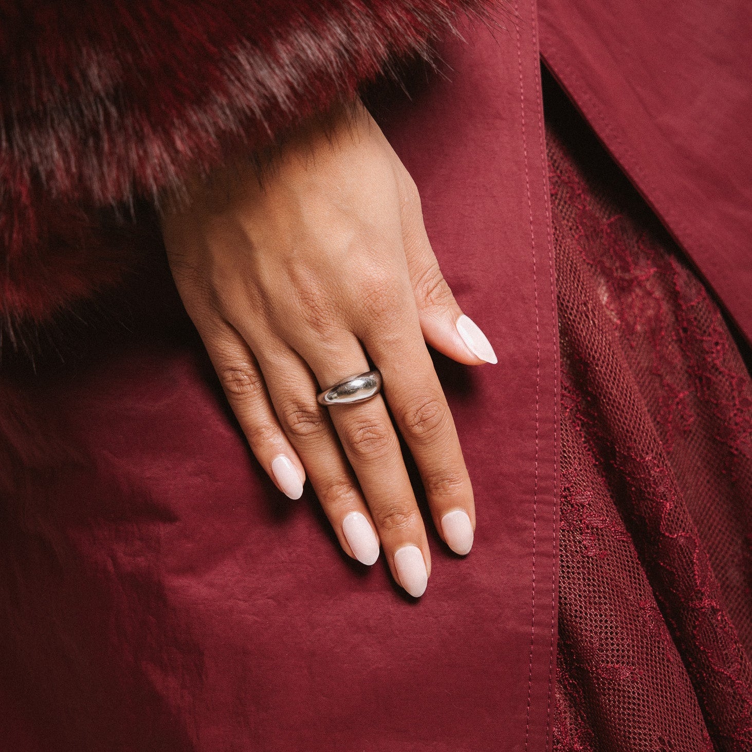 Family First Maniac Nails Anna Nooshin design light pink on hand with rink and dark red clothing 