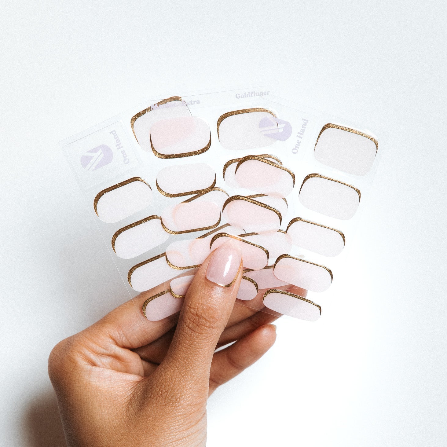 Goldfiger Maniac Nails Light transparent pink with gold line nail art by Anouk Nijs on hand and sheet