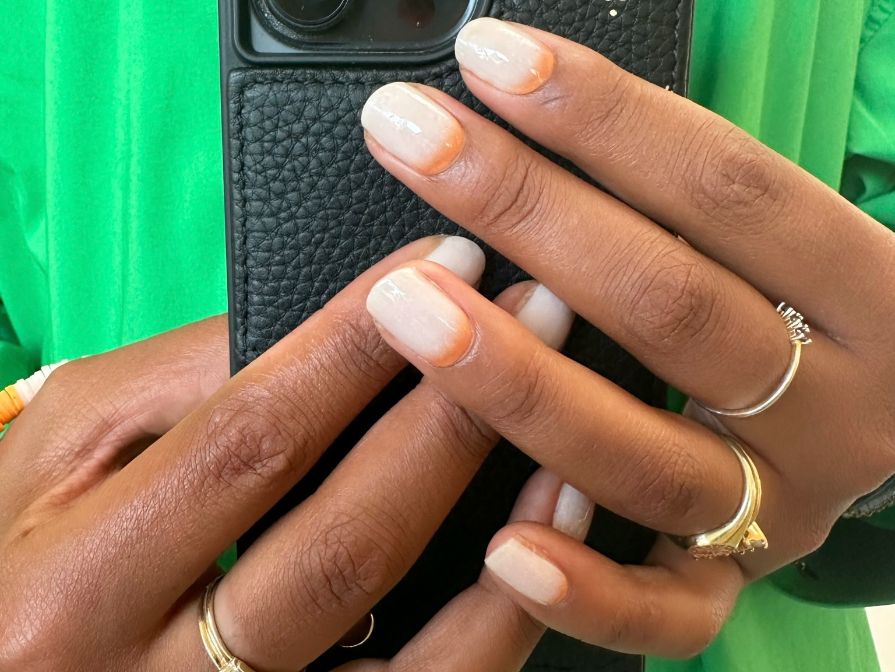 Maniac gellak sticker Sunrise hand op iPhone met groene bloes op achtergrond