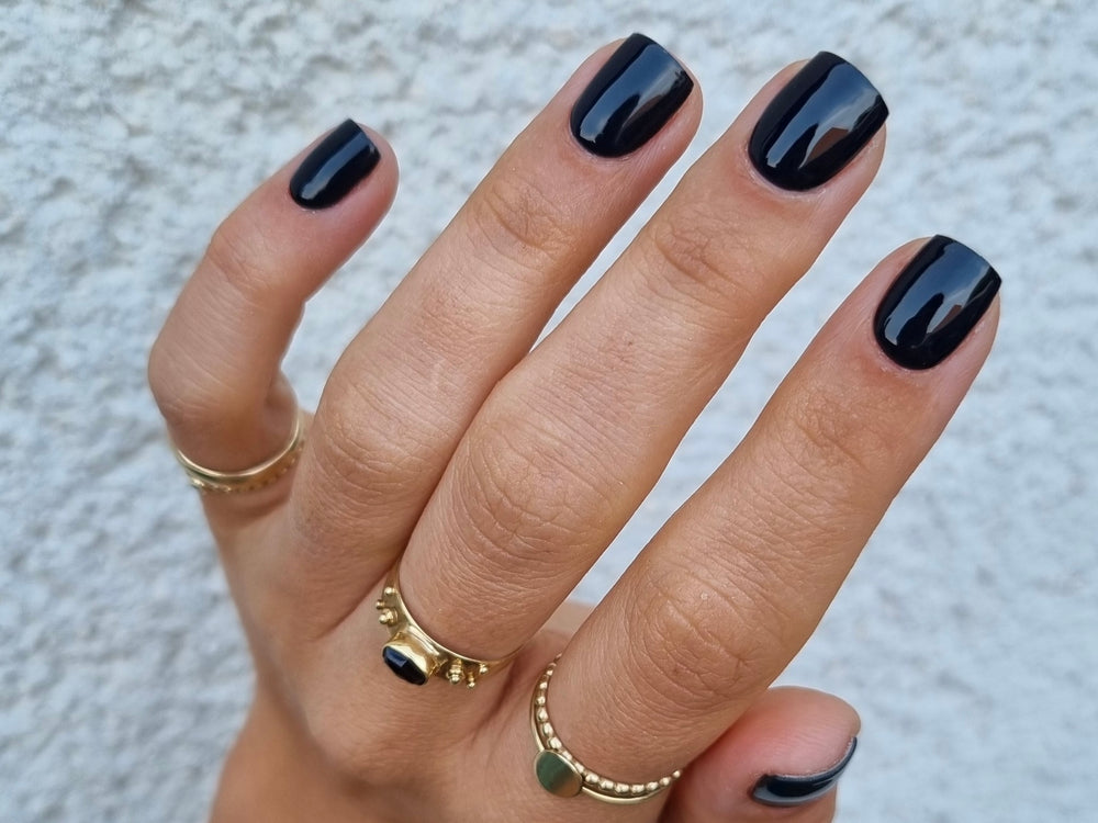 Hand met zwarte nagels van Maniac gellak stickers