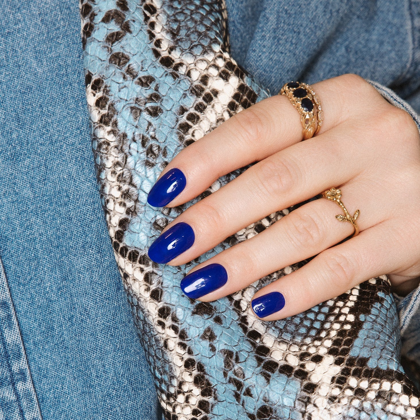 Maxima Blue Maniac nails royal blue gel stickers on hand with jeans and snake skin 
