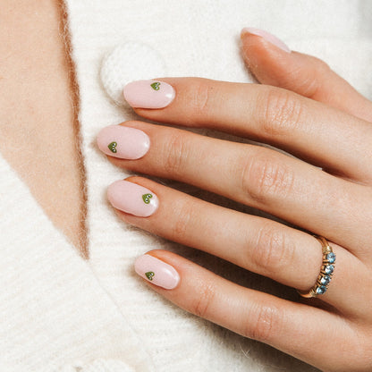 Minimal Crush Maniac Nails Light pink nail with green heart with eyes on hand white sweater 