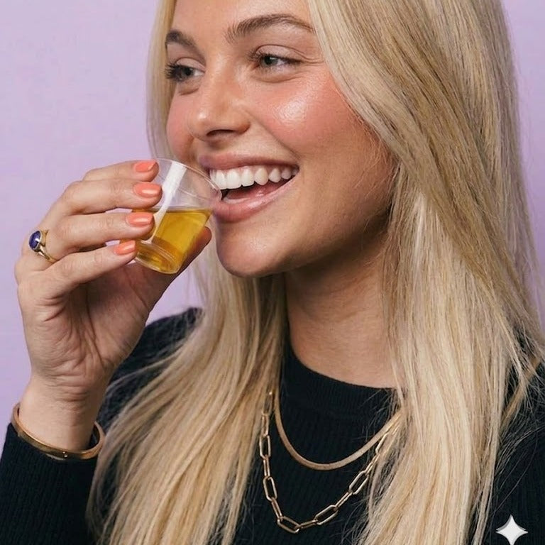 Lifestyle: profile view of woman drinking the Maniac Nails Nail Vitamin Shot.