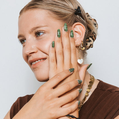 Model with Old Money gel nail stickers by Maniac Nails, sage green check manicure