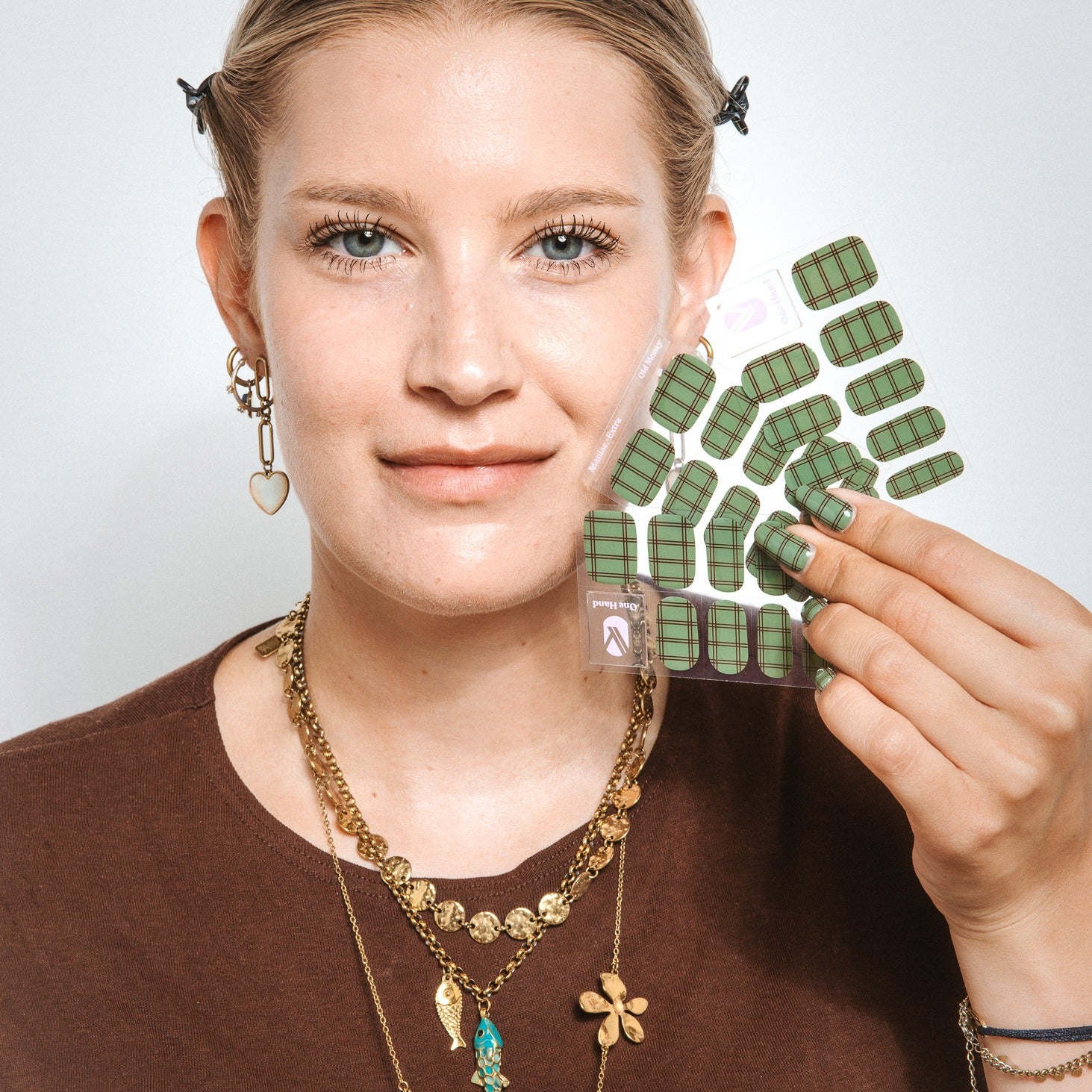 Model holding Old Money gel nail sticker sheets by Maniac Nails
