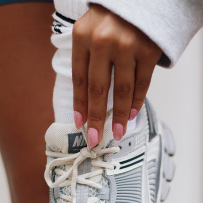 Parul Pink manicure met gel nail strips bij een sneaker - Maniac Nails