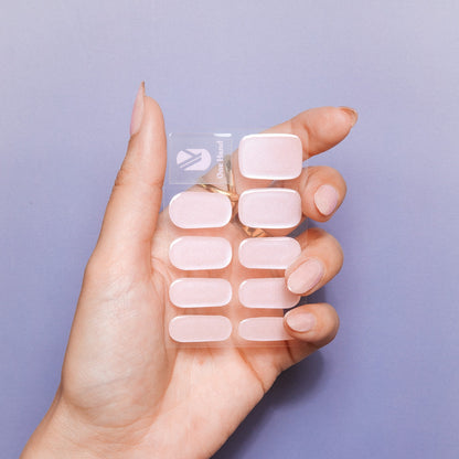 Hand holding Strawberry Glaze nail sticker sheets by Maniac Nails, soft pink gel nail stickers
