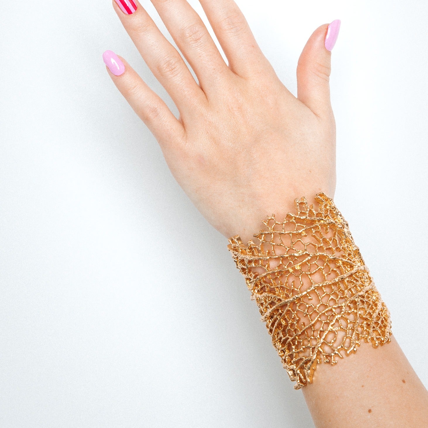 Hand with Suzy's Candy nail stickers by Maniac Nails and a gold bracelet, easy salon quality gel nails at home