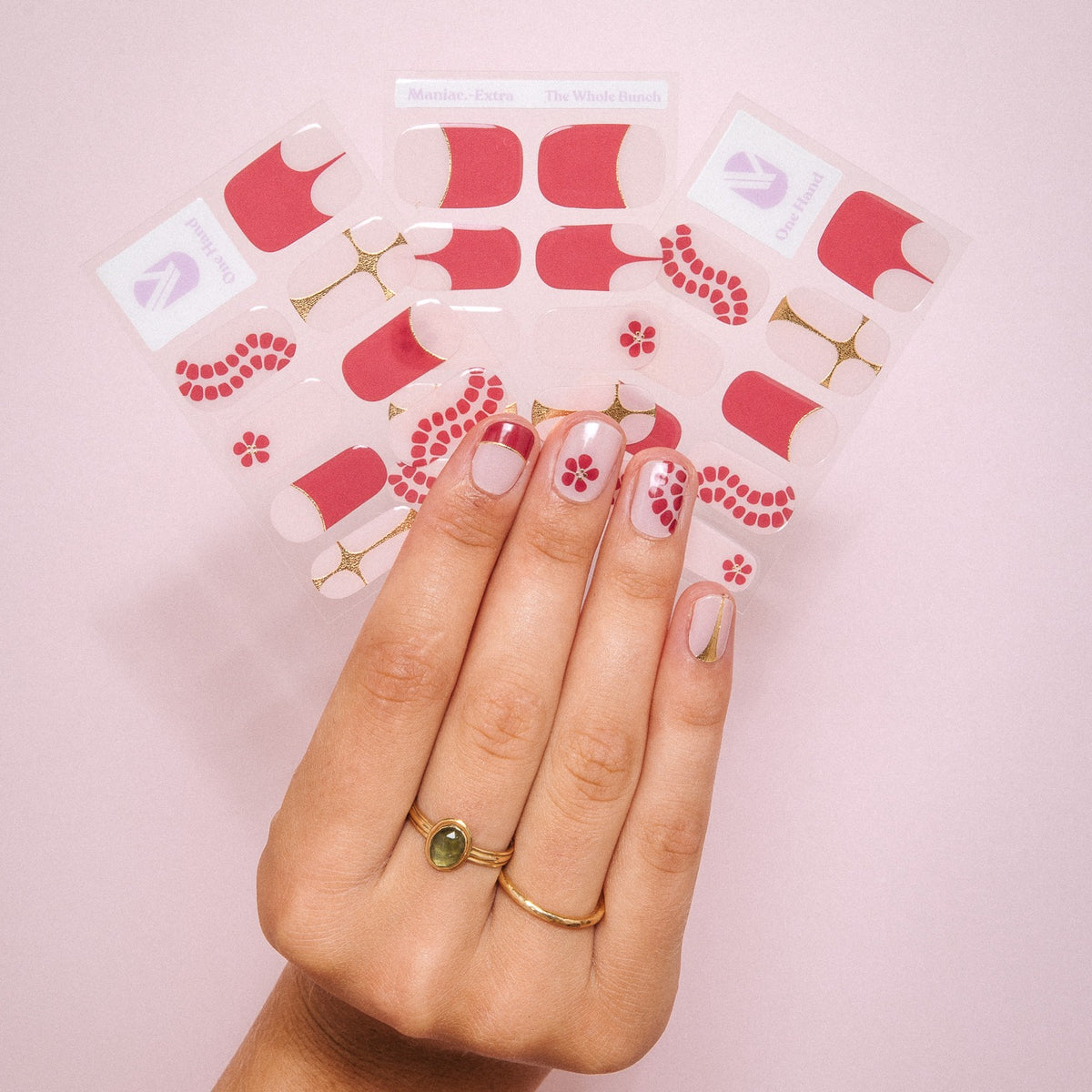 Hand holding The Whole Bunch gel nail sticker sheets by Maniac Nails, floral nail wraps