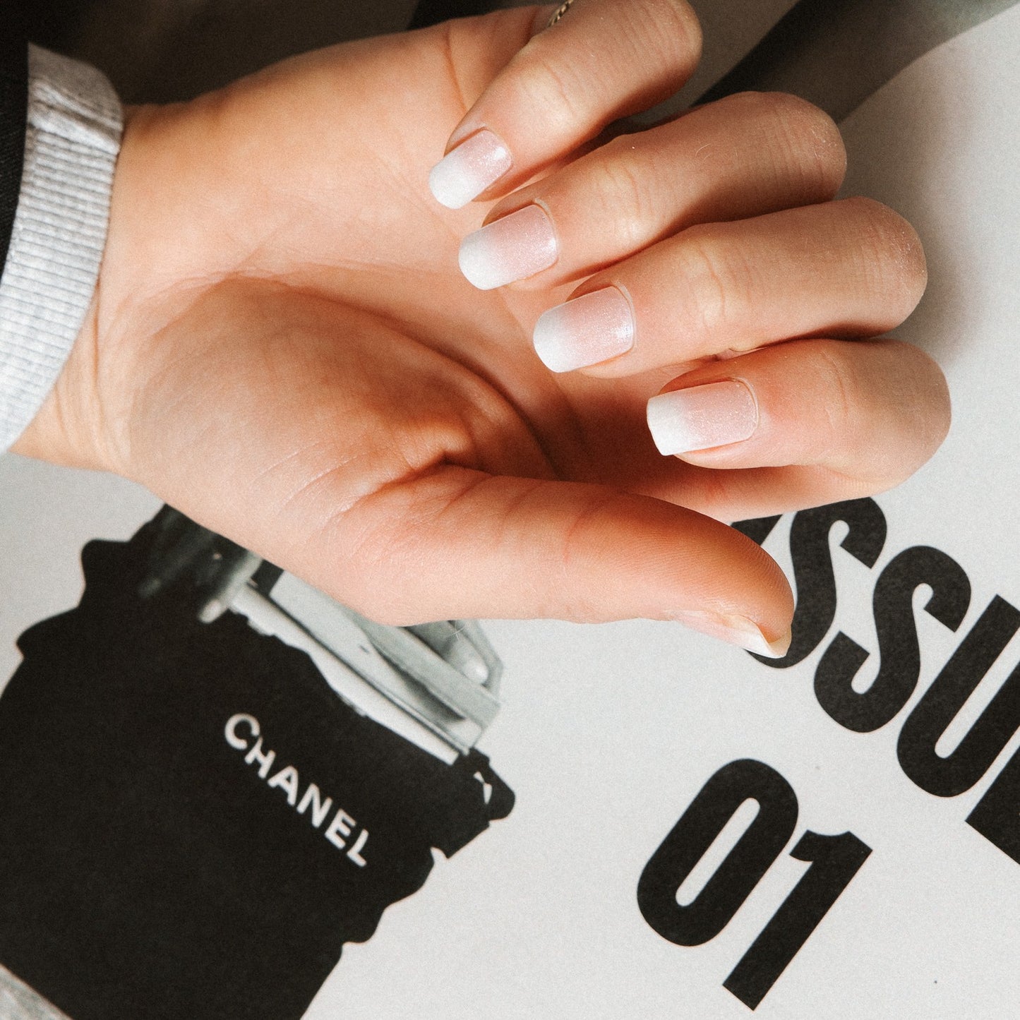 Close-up of Timeless French Glitter gel nail stickers by Maniac Nails, glittering white tips