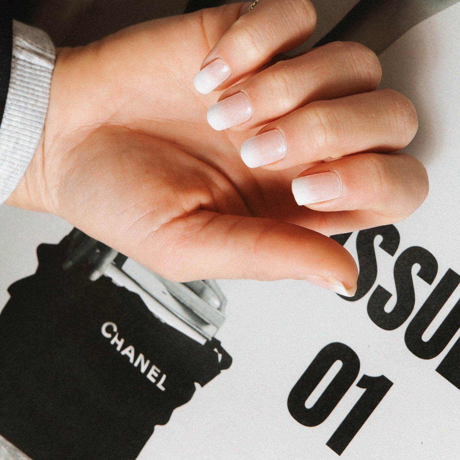 Close-up of Timeless French Glitter gel nail stickers by Maniac Nails, glittering white tips