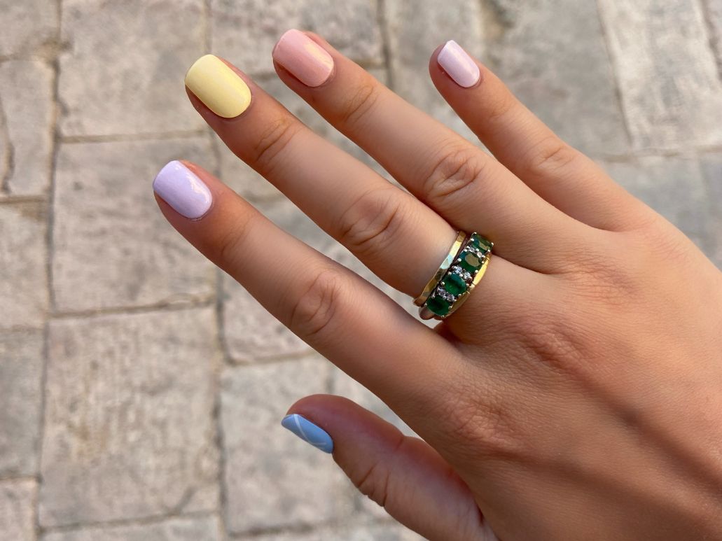 Pastel rainbow nail art on hands with Maniac gel polish stickers